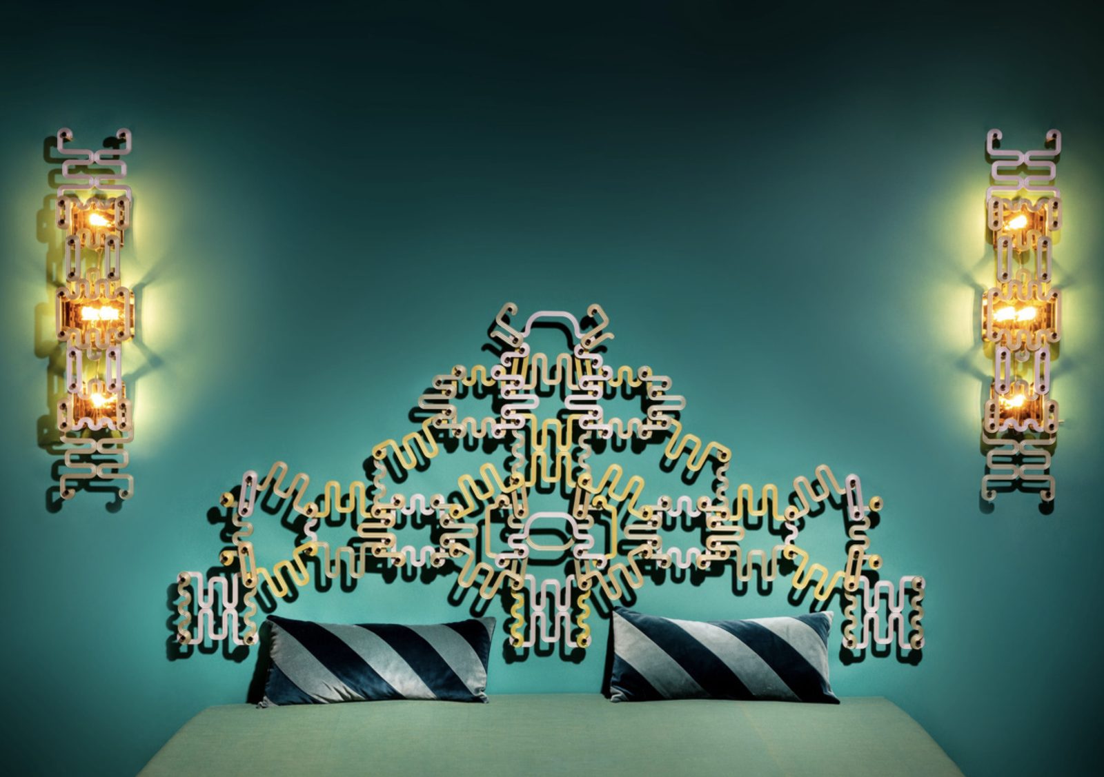 Glass sconces and wall installation against a teal wall